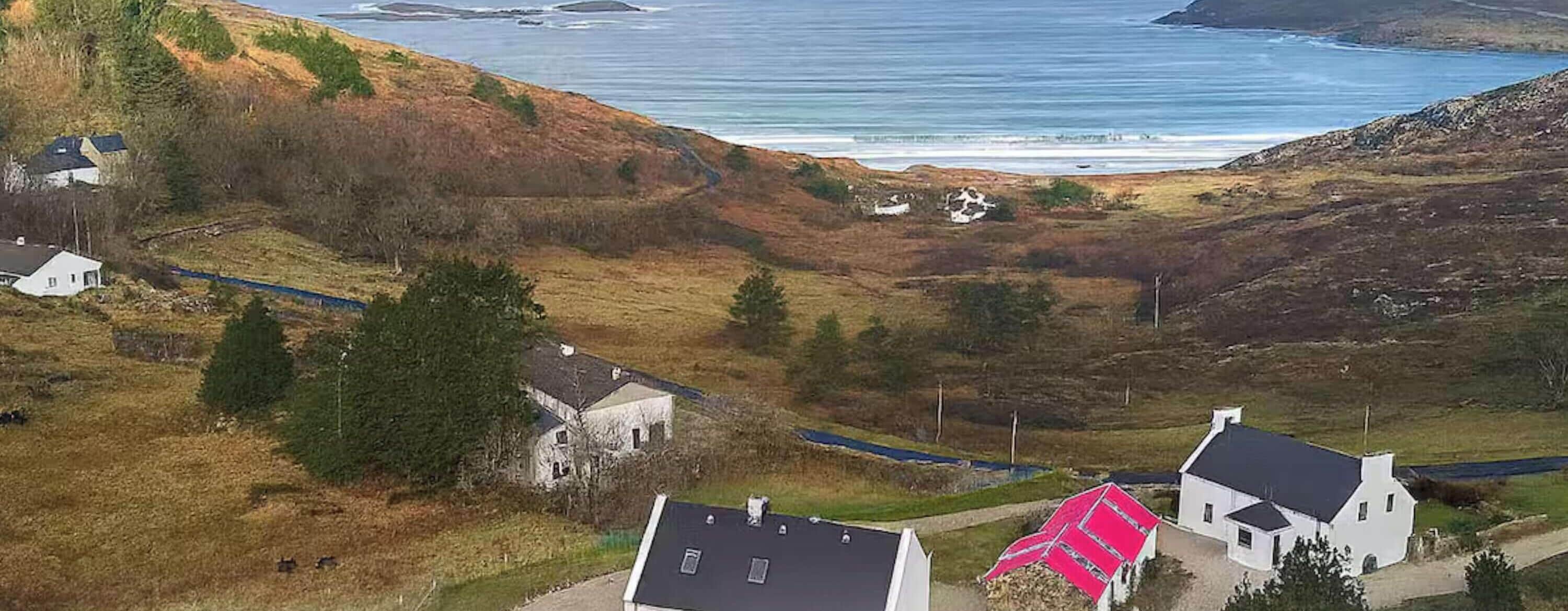 Un paisaje costero con casas, un camino y vista al mar.