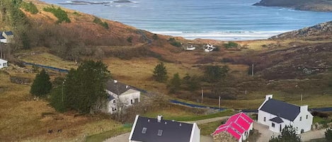 A coastal landscape with houses, a road, and a view of the sea.