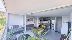 A modern open-plan living area with a sofa, dining table, and kitchen. - 2-bedroom apartment in tranquil Santafe de Antioquia with AC (Santafe de antioquia)