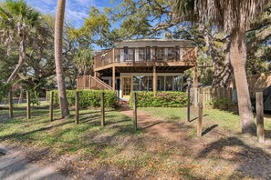 A two-story wooden house with a balcony, surrounded by trees and a garden. - 5 Bedrooms, Walkable Location (St Simons Island)