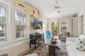 A living room with a television, a coffee table, a sofa, and a blue chair. - 5 Bedrooms, Walkable Location (St Simons Island)