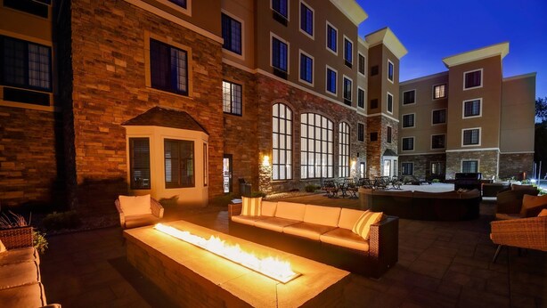 A courtyard with outdoor seating, a fire feature, and a building with multiple windows and balconies. - King Suite w/ Pool & Breakfast | Near Downtown (Holland)