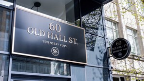 Placa com o texto '60 Old Hall St.', 'SevStay Plus' e um logotipo.