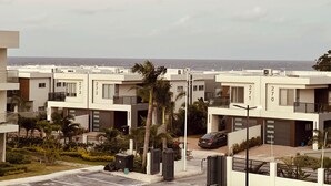 Een woonwijk met moderne gebouwen, genummerde adressen en uitzicht op zee.