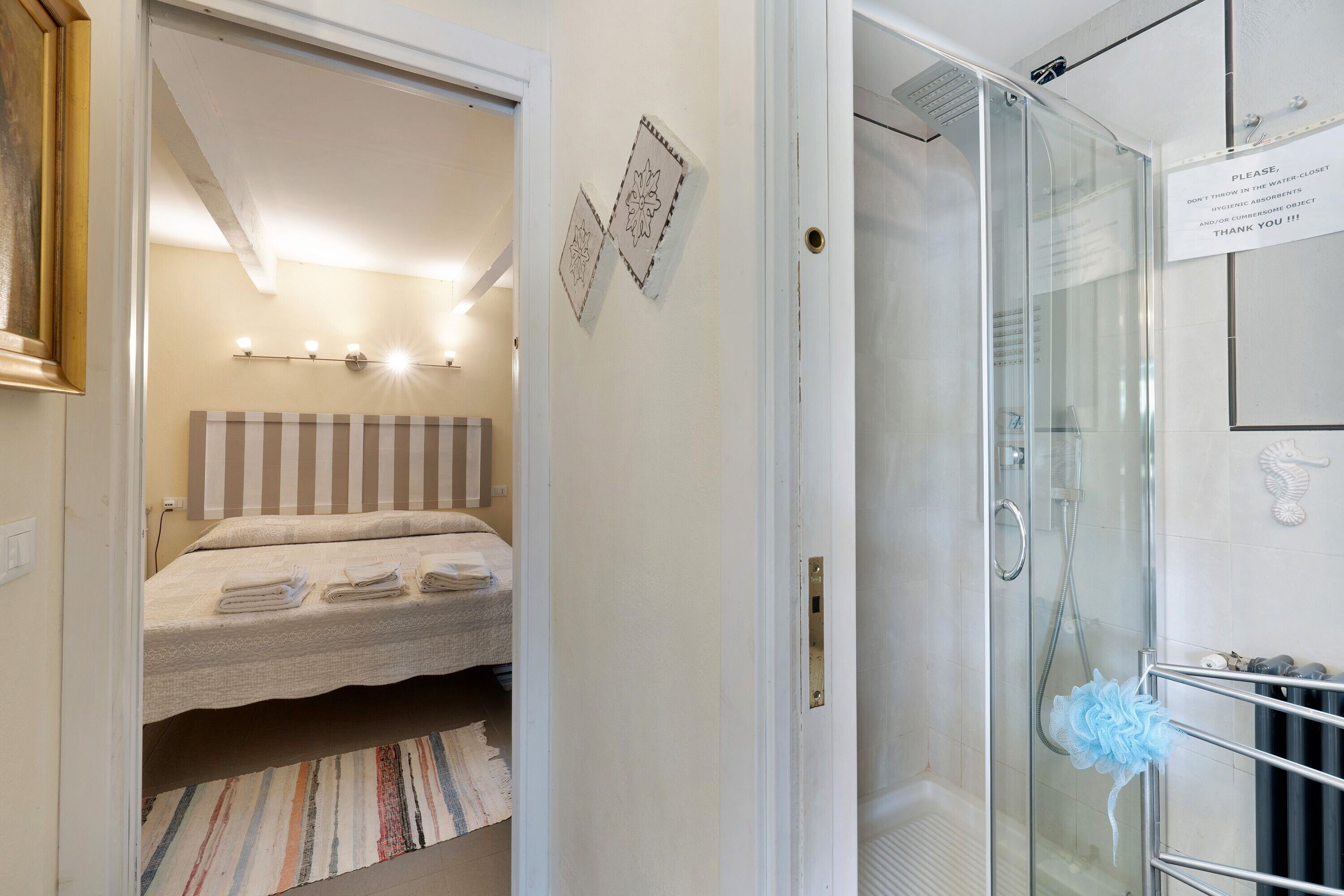Ett hotellrum med en säng, en dusch och ett badrum.