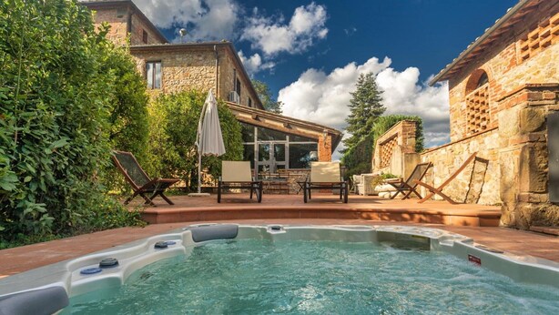 Ein Whirlpool in einem Garten mit Steinbauten und einer Terrassenanlage.