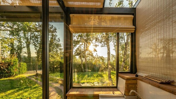 Une salle de bain moderne avec une grande fenêtre, un lavabo et un store en bambou.