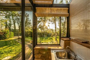 Ein modernes Badezimmer mit großem Fenster, Waschbecken und Jalousie aus Bambus.