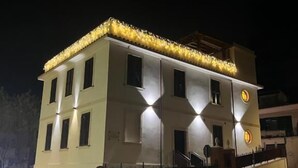 A multi-story building with a flat roof, a staircase leading to the upper floor, and a sign indicating a restaurant. - Residenza Colonna (Lanuvio)