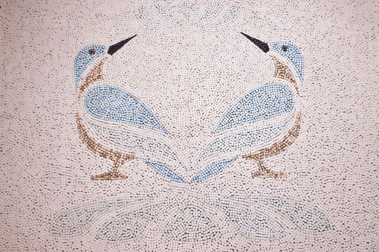 Une mosaïque représentant deux oiseaux aux formes symétriques.