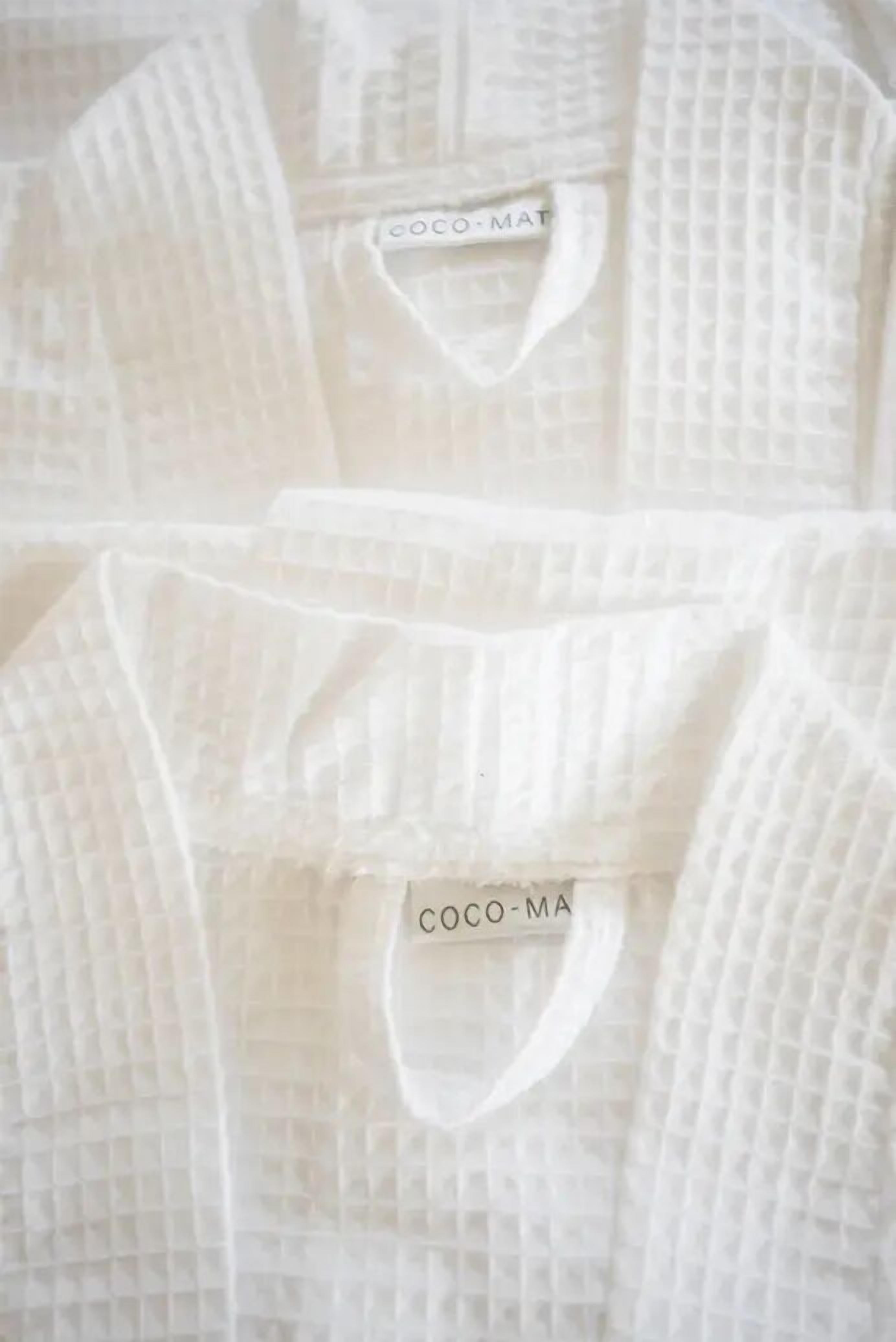 A close-up of a white garment with a tag labeled 'COCO-MAT'.