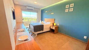 Un dormitorio con cama, mesita de noche y vistas al exterior.