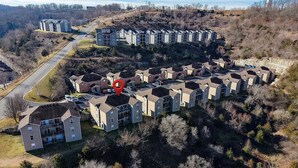 Zona residencial con varios edificios de apartamentos, una calle y un edificio grande al fondo.