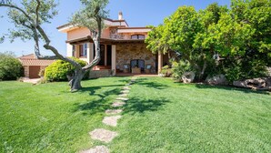Una casa con fachada de piedra, un camino de piedra que lleva a la entrada y un césped bien cuidado.