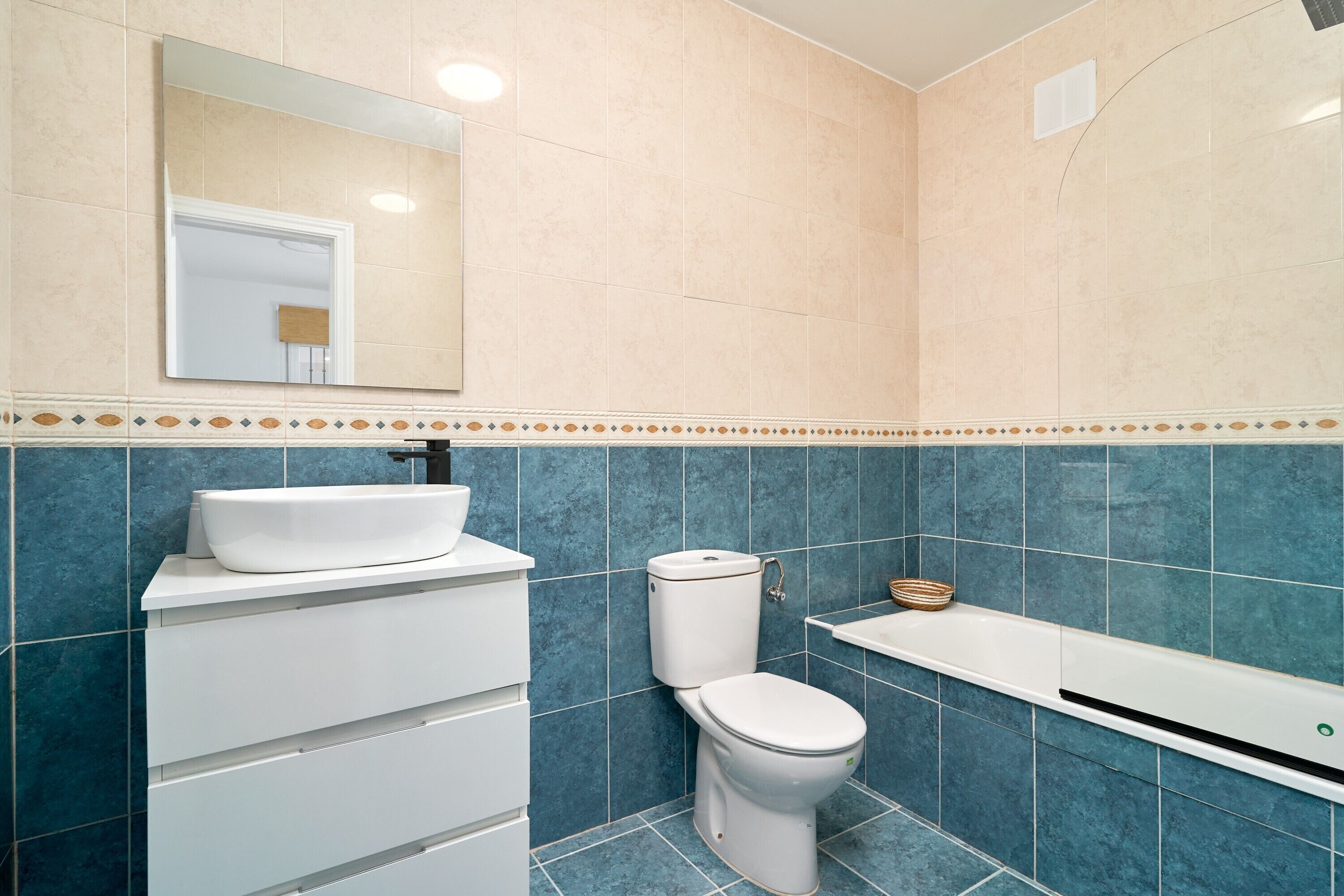 Un baño con lavamanos, inodoro y bañera.