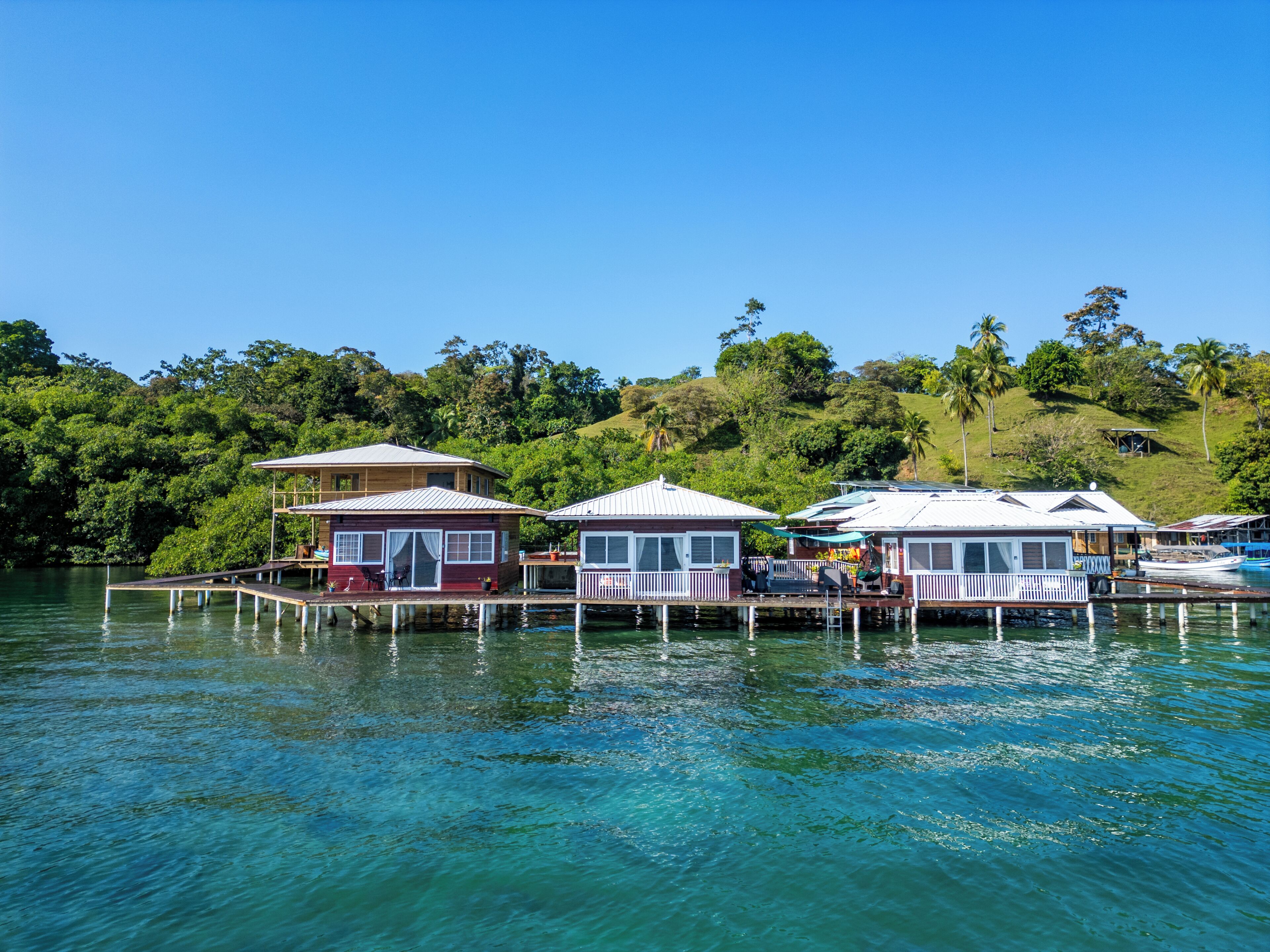 A waterfront property with multiple buildings connected by docks, surrounded by lush greenery.