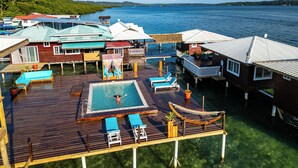 A resort with a swimming pool, lounge chairs, and a view of the sea. - Coral Wing Casitas (Bastimentos)