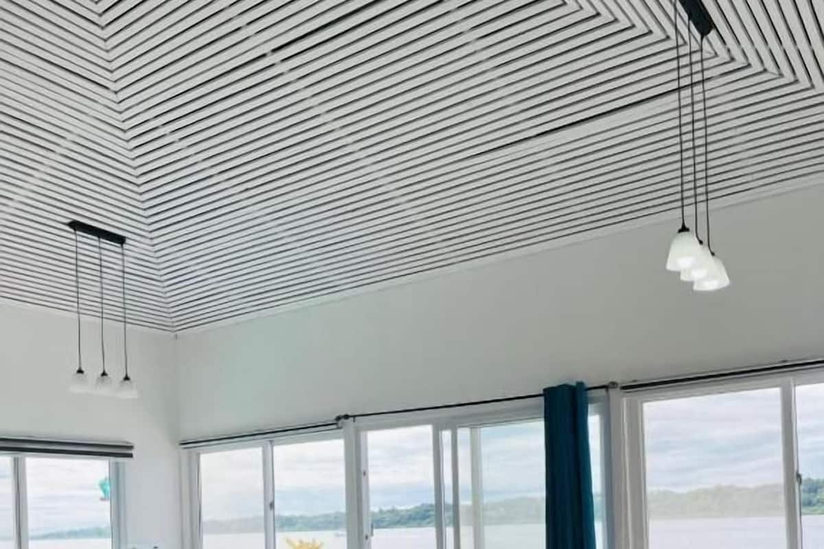 Ein modernes Interieur mit einer Küche, einem Essbereich mit rundem Tisch und einem Bett mit floraler Bettwäsche.