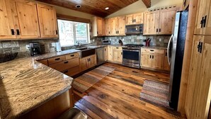 A kitchen with wooden cabinets, granite countertops, a stainless steel refrigerator, and a built-in oven. - Gorgeous Donner Lake 3BR + Loft Modern Home in Truckee (Truckee)