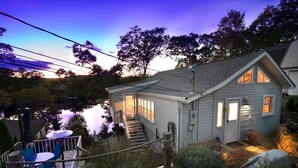 Una casa con terraza, escalera y vista al agua.