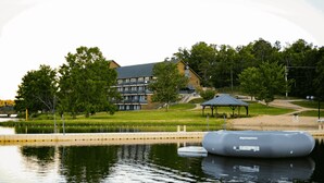 Blick auf einen See mit einem Gebäude, einem Pavillon und einem schwimmenden Steg.