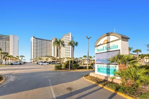 A beach resort sign with palm trees and a clear sky. - SunDestin Resort Unit 1515 (Destin)