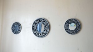Tres espejos decorativos colgados en la pared.