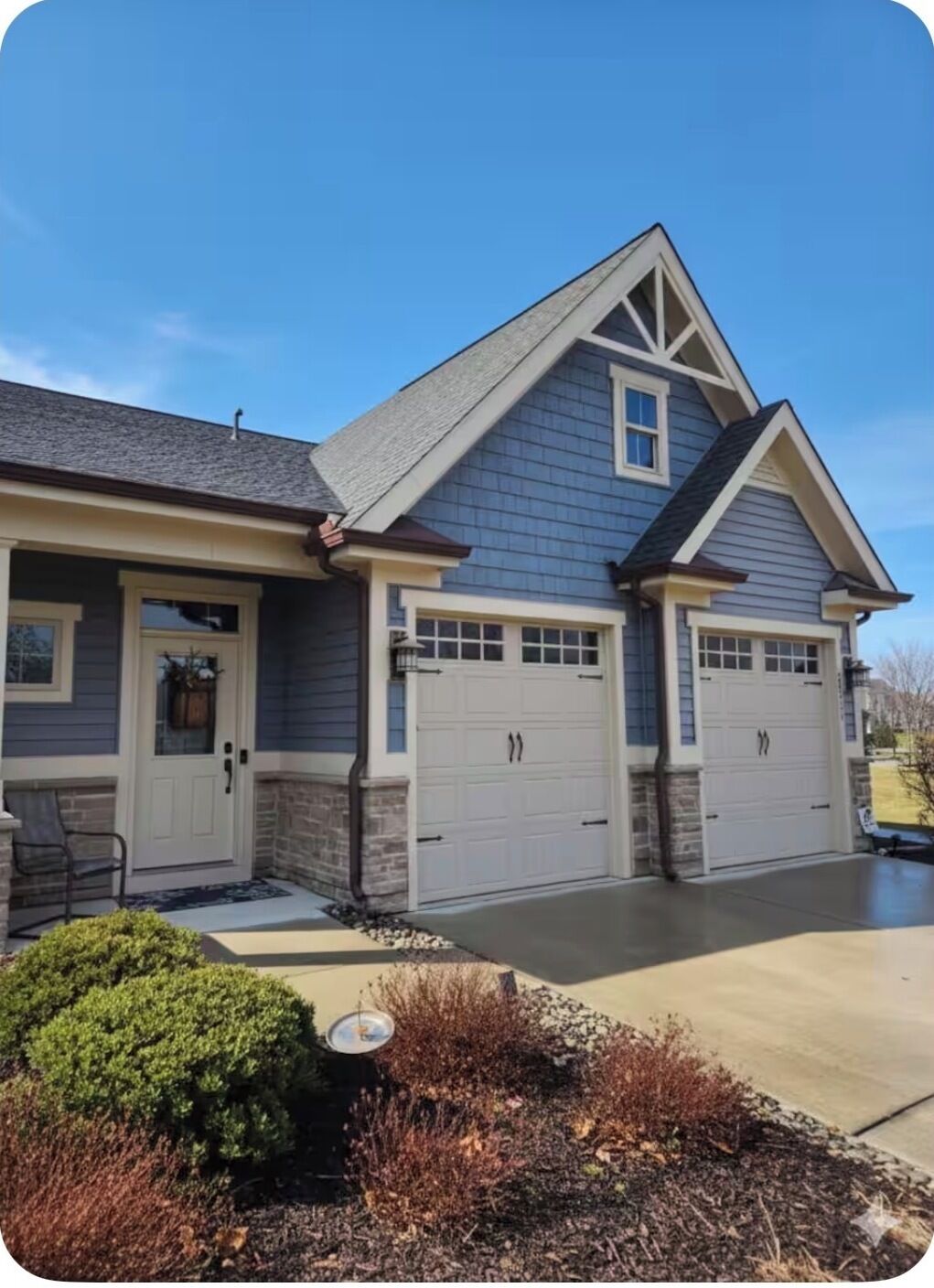 A two-story house with a garage, a front door, and a small porch.
