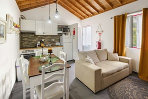 Un espacio habitable compacto con kitchenette, comedor y sofá.