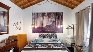 A bedroom with a large horse-themed poster, a wooden headboard, a bed with multiple pillows, and a hanging light fixture. - Studio 'Quinta do Malhinha' with Mountain View, Shared Terrace and Wi-Fi (Posto Santo)
