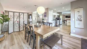 Een moderne keuken met een houten eettafel, stoelen en een hanglamp.