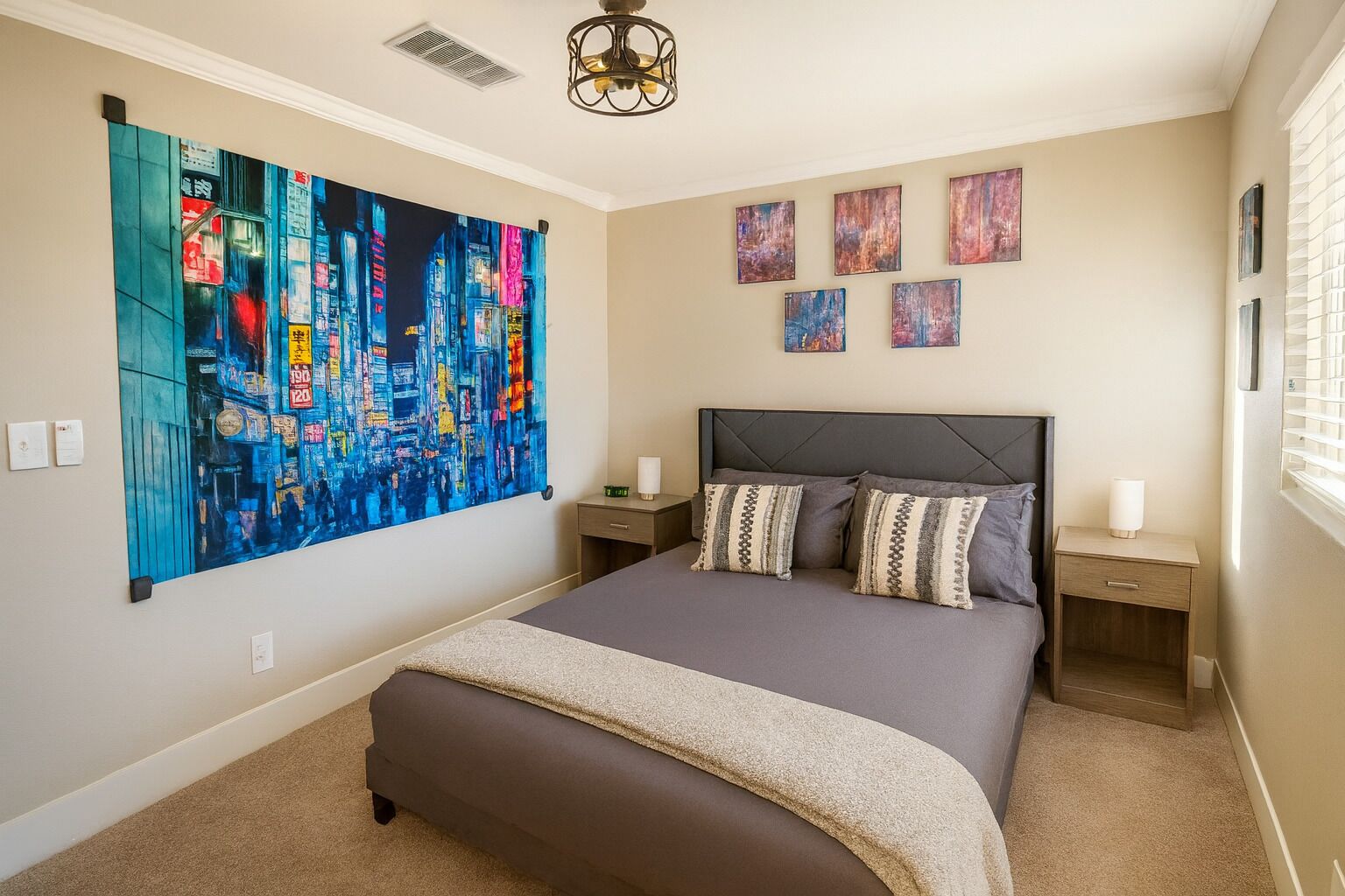 Une chambre avec un grand lit, deux tables de chevet, une lampe de chevet, un luminaire au plafond et un grand tableau abstrait accroché au mur.