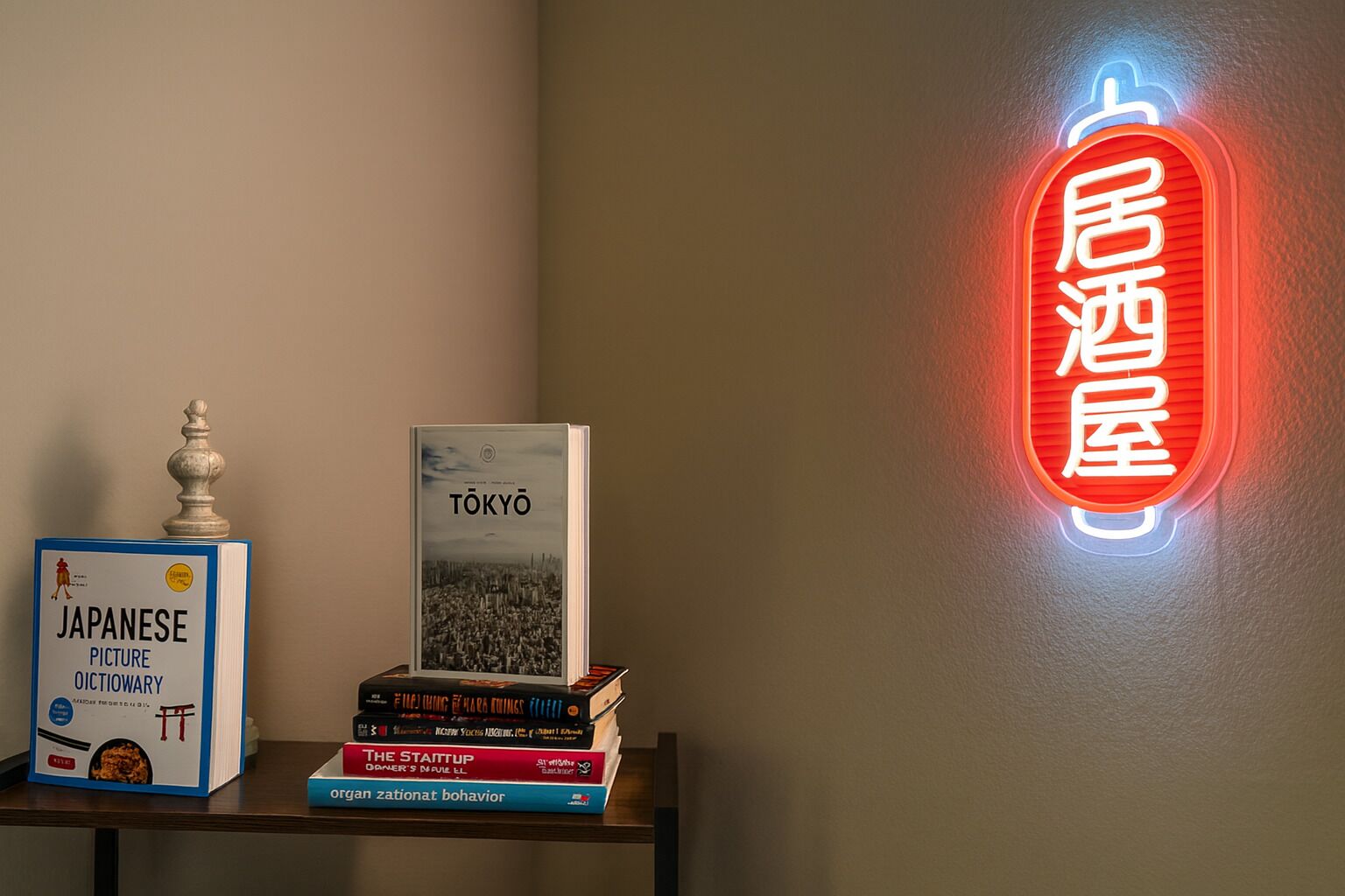 A stack of books on a shelf, a neon sign with Japanese characters, and a decorative object.