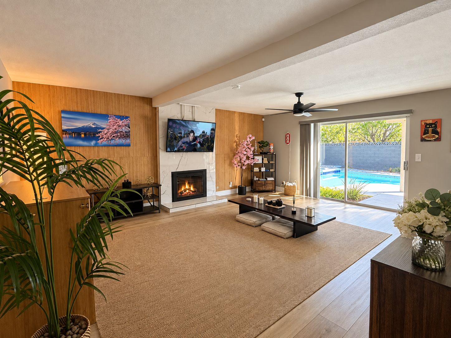 Una sala de estar moderna con chimenea, televisión y vista a una piscina.