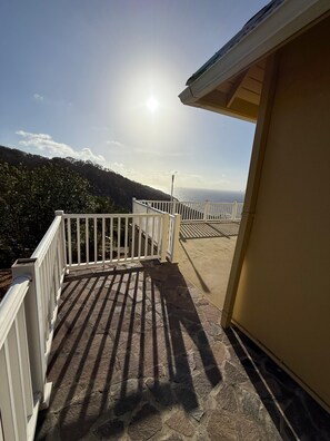 A balcony with stone flooring, white railings, and a view of the sea. - Private Oceanview Escape in Bequia Peaceful Caribbean Retreat (Port Elizabeth)