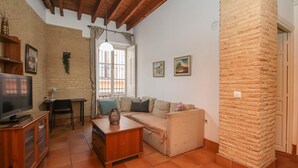 Un salon avec un canapé, un téléviseur et un meuble en bois.