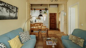Un salon comprenant un canapé, une table basse et un coin repas avec des chaises et une table.