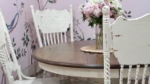 A dining area with a round table, white chairs, and a floral wallpaper background. - Mon Sherri - The Cottage (Loxley)