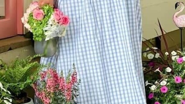 A person standing on a porch holding a bouquet of flowers. - Mon Sherri - The Cottage (Loxley)