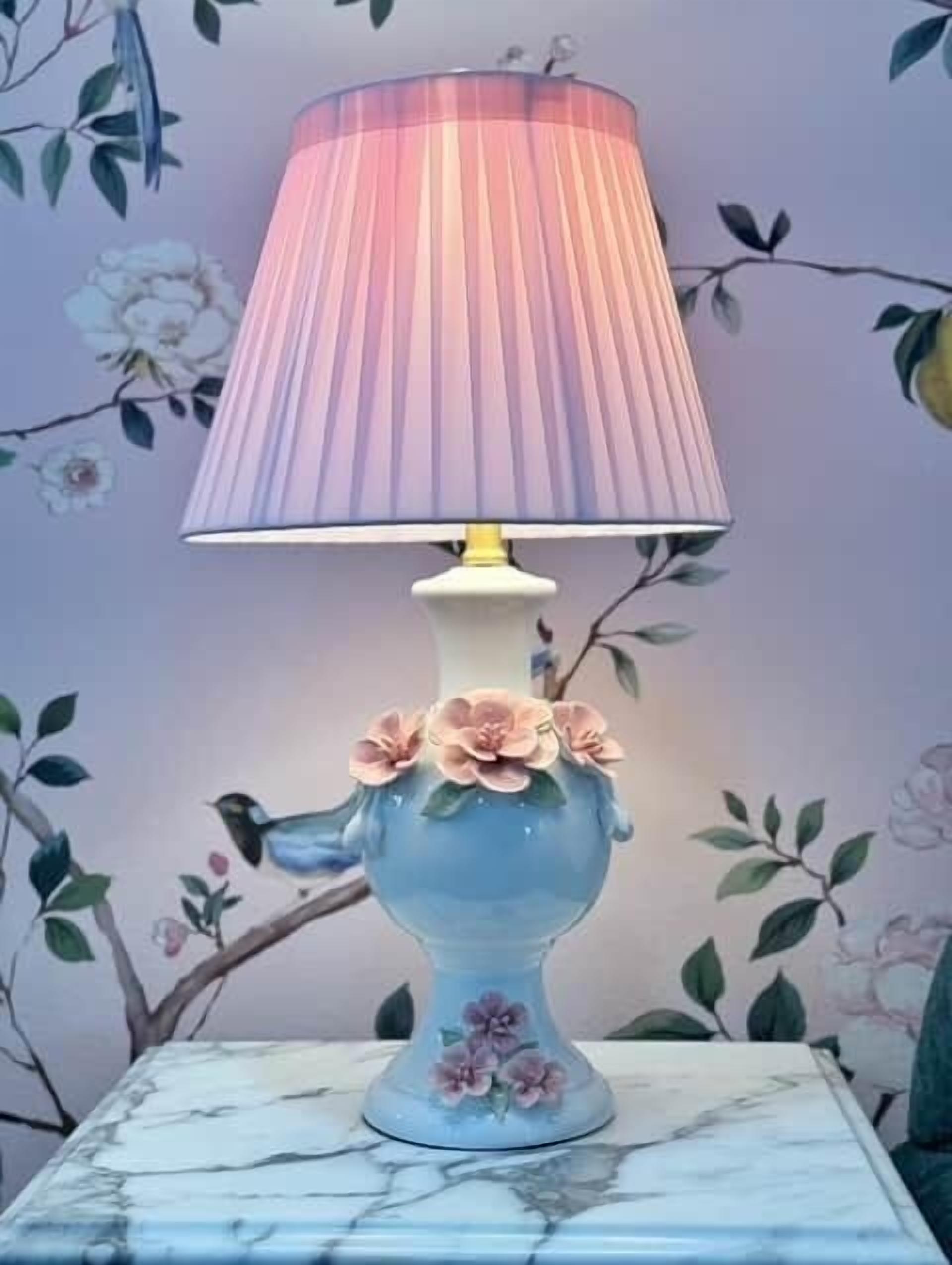 A table lamp with a floral design on a marble surface.