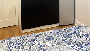 Une cuisine compacte avec des meubles noirs, un réfrigérateur en acier inoxydable, un four à micro-ondes et un pare-feu en carreaux.