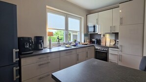 A compact kitchen with a microwave, coffee maker, and oven.