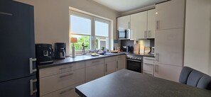 A compact kitchen with a microwave, coffee maker, and oven.