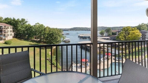 Ein Balkon mit Blick auf einen Fluss, Boote und einen Poolbereich.