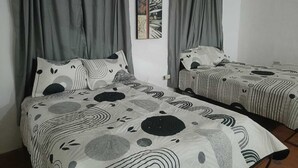 A room with two beds, grey curtains, and a painting on the wall. - CASA ALBINO, NICE HOUSE WITH 3 BEDROOMS, VERY COMFORTABLE AND CENTRALLY LOCATED. (Izamal)