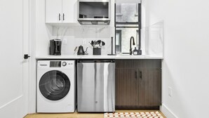 Una cocina compacta con lavadora, refrigerador y microondas.