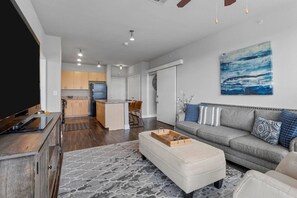 A modern living room with a sofa, coffee table, and artwork on the wall.
