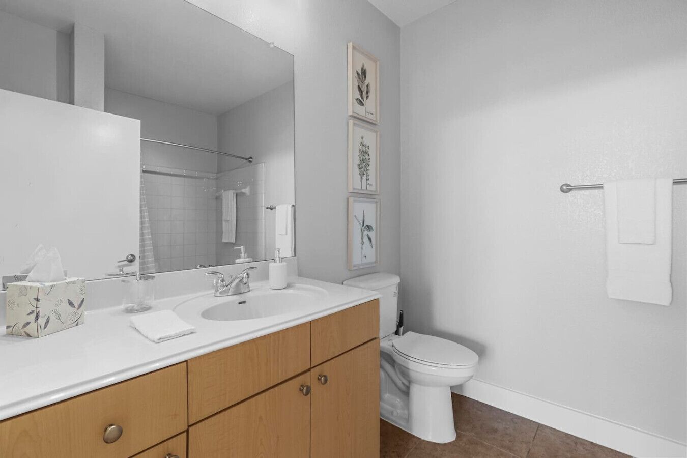 Un bagno moderno con doppio lavandino, un water e un grande specchio.
