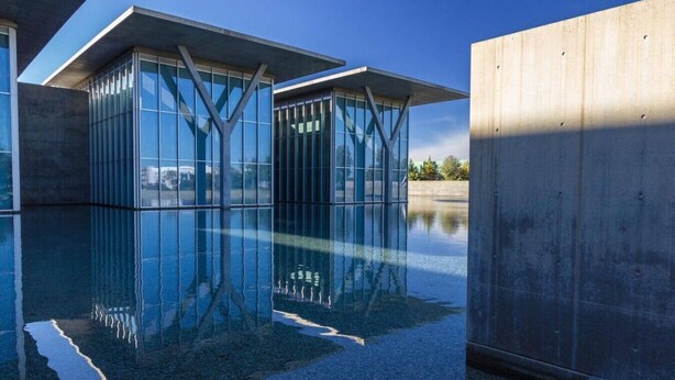 A modern building with glass walls and a concrete structure. - Shop, dine, enjoy - walk Downtown! (Fort Worth)