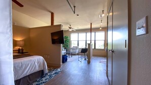A hotel room with a bed, a TV, a desk, a chair, and a large window. - Relaxing Extended stays, walk Downtown! (Fort Worth)